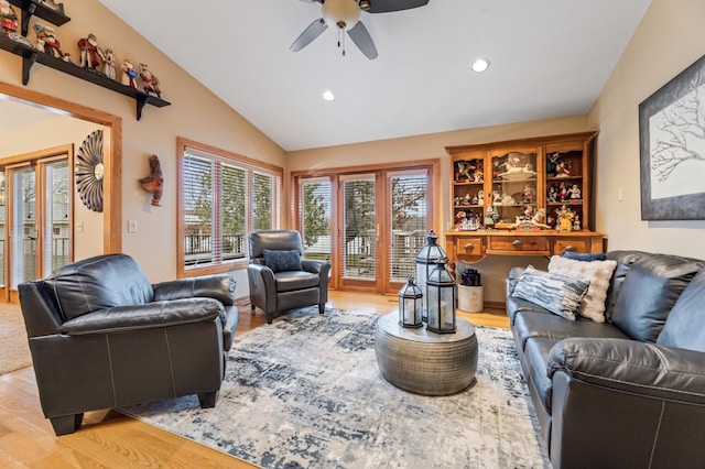 living room featuring light hardwood / wood-style floors, vaulted ceiling, and ceiling fan