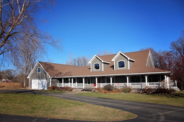 farmhouse-style home with covered porch, a front yard, and a garage