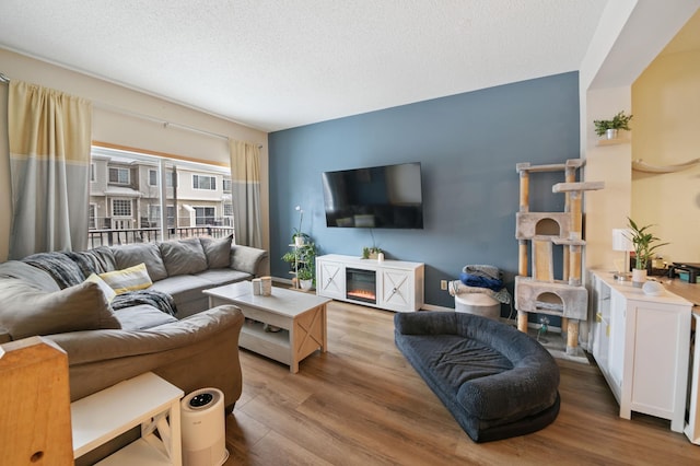 living room with light hardwood / wood-style floors and a textured ceiling