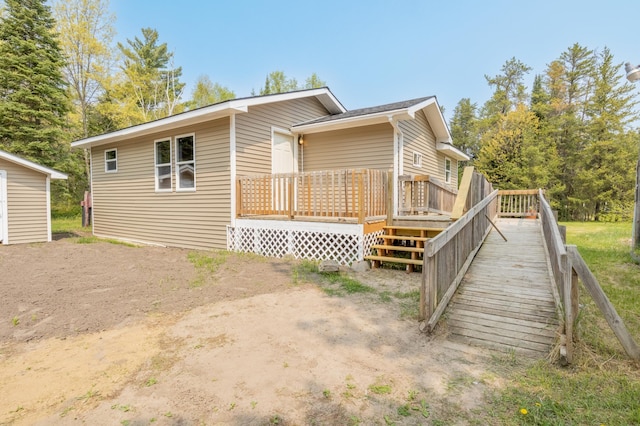 rear view of property featuring a wooden deck