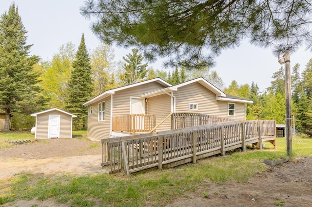 rear view of house with a shed and a wooden deck