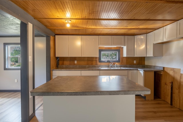 kitchen with white cabinets, light hardwood / wood-style floors, wooden ceiling, and sink