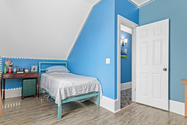 bedroom with wood-type flooring and lofted ceiling