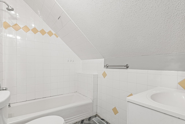 bathroom featuring a textured ceiling, vaulted ceiling, toilet, tile walls, and tiled shower / bath