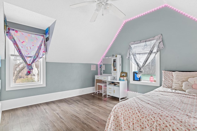 bedroom with ceiling fan, wood-type flooring, and lofted ceiling