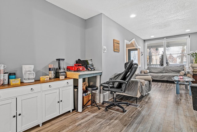 interior space featuring a textured ceiling and light hardwood / wood-style floors