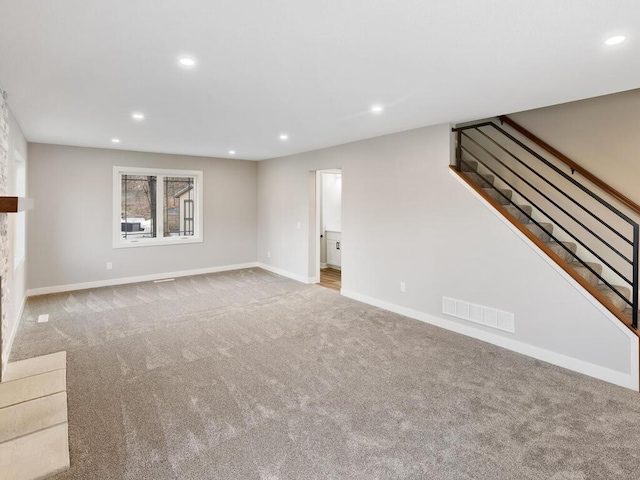 unfurnished living room with a fireplace and light carpet