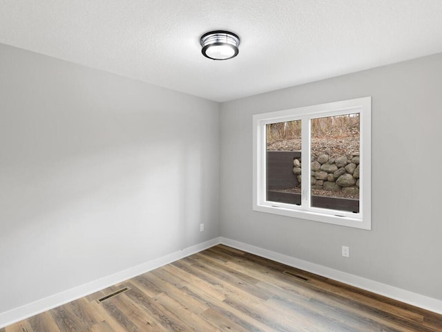 unfurnished room with hardwood / wood-style flooring