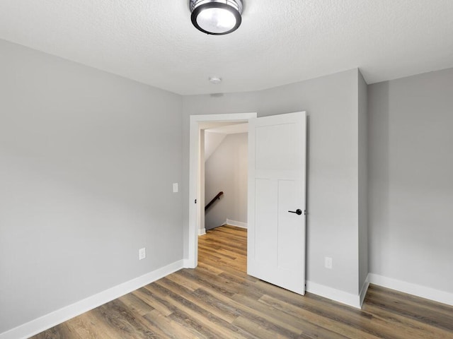 unfurnished bedroom with wood-type flooring and a textured ceiling