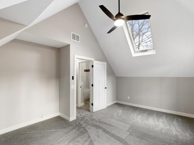 bonus room with vaulted ceiling with skylight, ceiling fan, and carpet