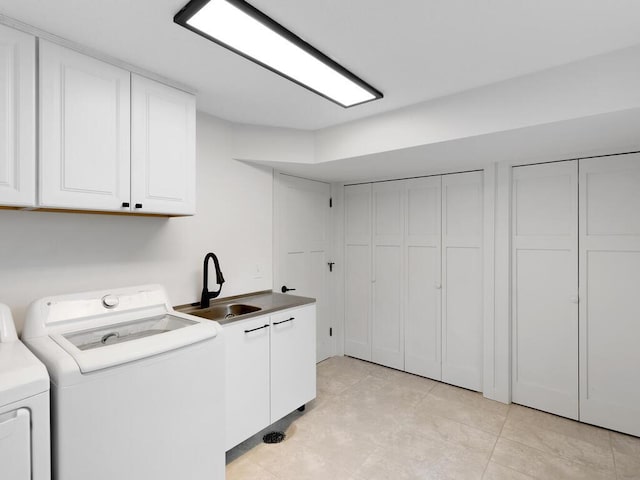 laundry room with washer and clothes dryer, sink, light tile patterned flooring, and cabinets