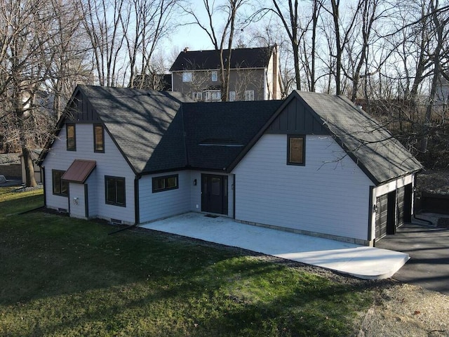 view of front facade featuring a garage, a patio area, board and batten siding, and a front yard