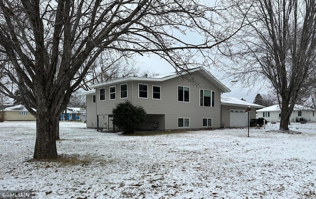 snow covered house with a garage