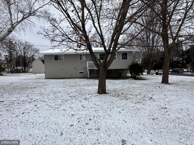 view of snow covered back of property