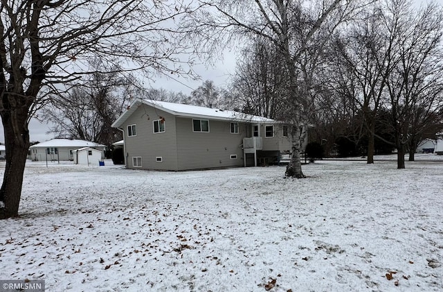 view of snow covered rear of property