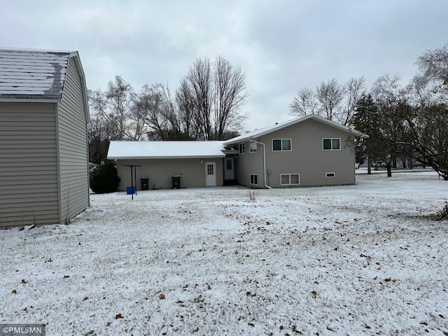 view of snow covered back of property