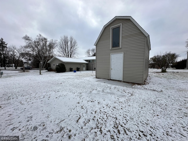 snow covered property featuring an outdoor structure