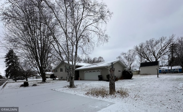 snow covered property featuring a garage