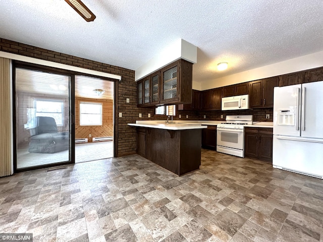 kitchen featuring kitchen peninsula, a kitchen breakfast bar, white appliances, and brick wall