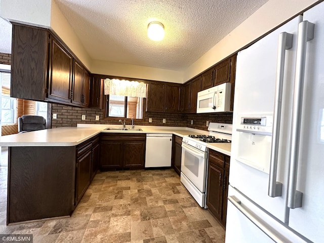 kitchen featuring sink, backsplash, kitchen peninsula, a textured ceiling, and white appliances