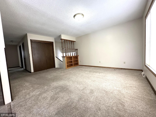 unfurnished bedroom with a closet, carpet, and a textured ceiling