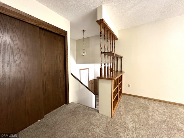 staircase featuring carpet floors, a chandelier, and a textured ceiling