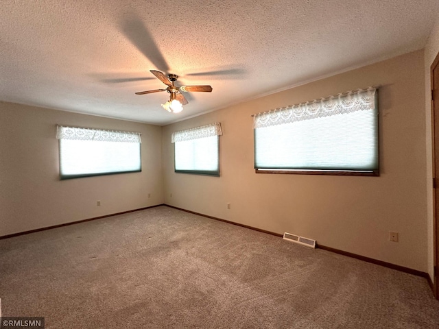 spare room with carpet, ceiling fan, and a textured ceiling