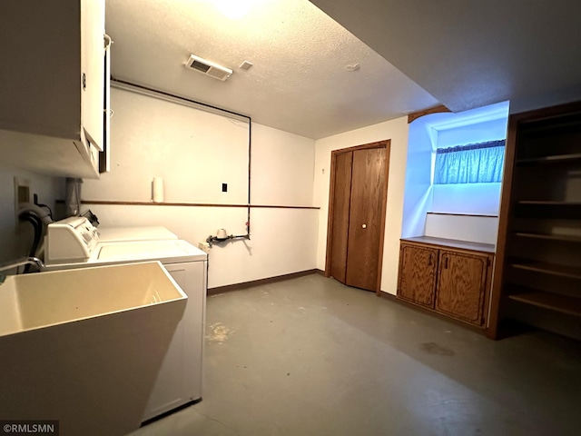 laundry area featuring sink, cabinets, and a textured ceiling