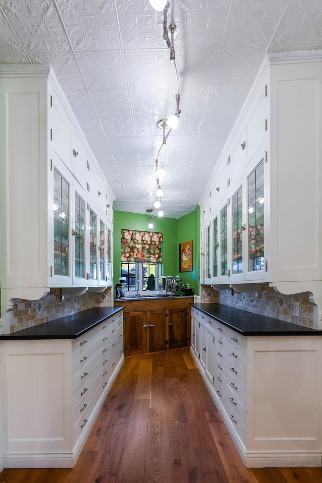661 Market St, Winona, MN 55987 - kitchen featuring decorative backsplash, dark hardwood / wood-style flooring, white cabinetry, and rail lighting