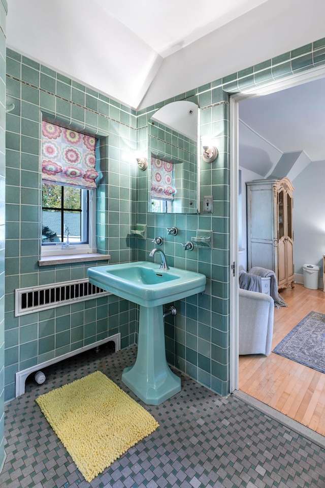 661 Market St, Winona, MN 55987 - bathroom with lofted ceiling, hardwood / wood-style floors, tile walls, and sink