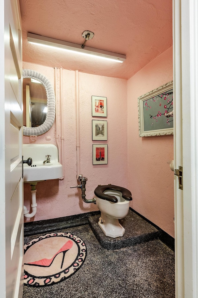 661 Market St, Winona, MN 55987 - bathroom featuring sink, toilet, and a textured ceiling