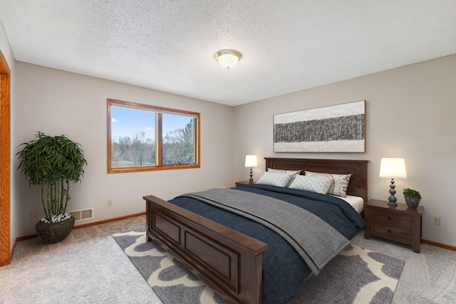 bedroom featuring visible vents, a textured ceiling, baseboards, and light carpet