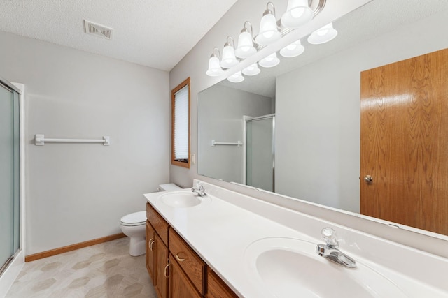 full bathroom featuring toilet, visible vents, a shower stall, and a sink