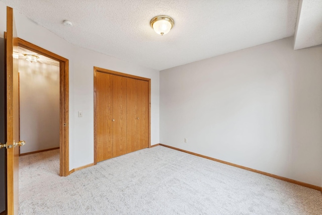 unfurnished bedroom with a closet, carpet, and baseboards