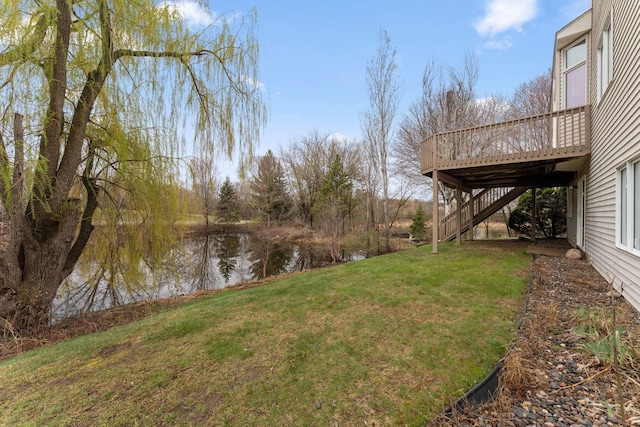 view of yard with stairway and a deck with water view