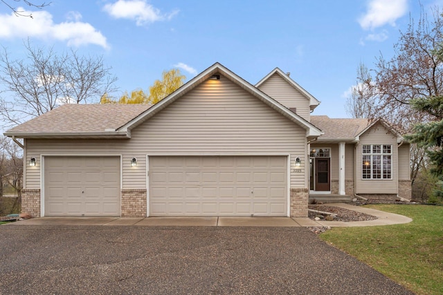 ranch-style house with brick siding, a garage, and aphalt driveway
