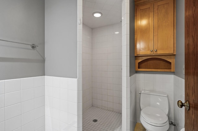 bathroom with tiled shower, tile walls, and toilet