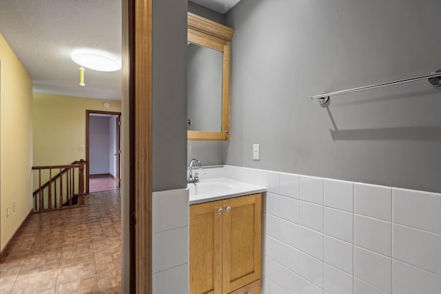 bathroom with vanity, tile walls, and a textured ceiling