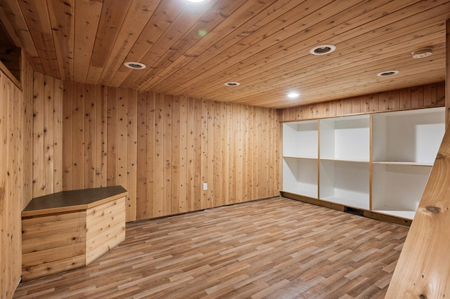 empty room with wood ceiling, wooden walls, and light hardwood / wood-style floors