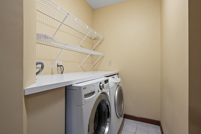 washroom featuring light tile patterned floors and washer and clothes dryer