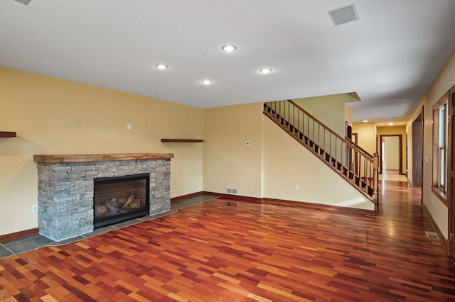 unfurnished living room featuring a fireplace and dark hardwood / wood-style flooring