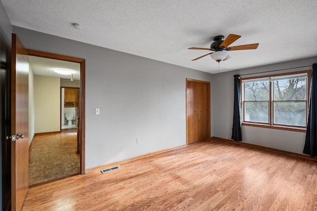 unfurnished bedroom with ceiling fan, light hardwood / wood-style flooring, and a textured ceiling