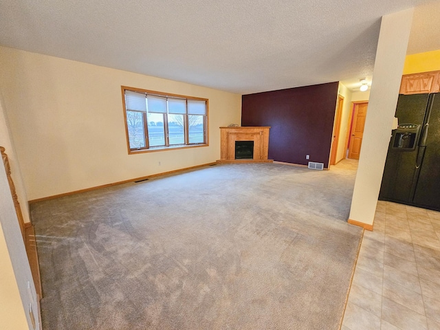 unfurnished living room with light carpet and a textured ceiling