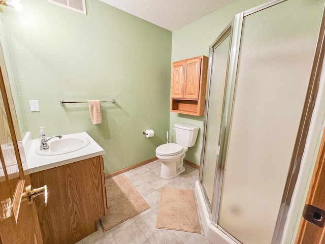 bathroom with vanity, toilet, a shower with door, tile patterned floors, and a textured ceiling