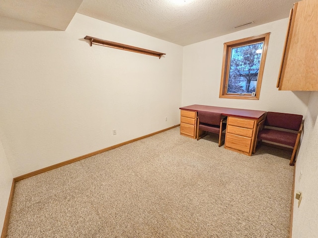 unfurnished office featuring light carpet and a textured ceiling