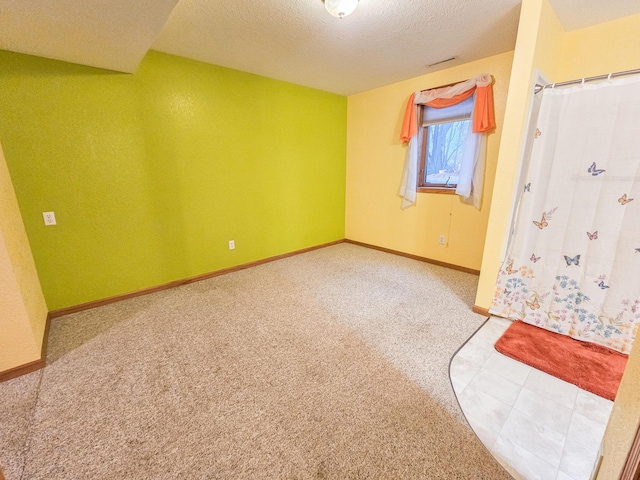 carpeted empty room featuring a textured ceiling