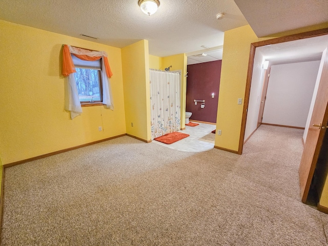 unfurnished room featuring carpet flooring and a textured ceiling