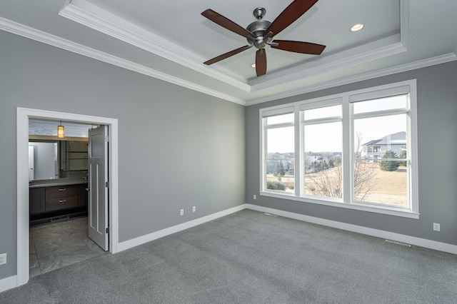 unfurnished bedroom with baseboards, carpet floors, crown molding, and a raised ceiling