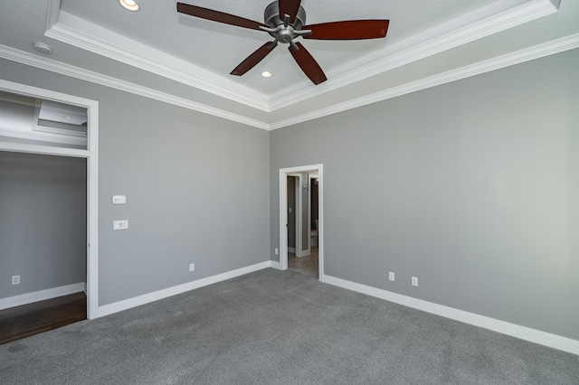 unfurnished bedroom featuring carpet, ornamental molding, a tray ceiling, and baseboards