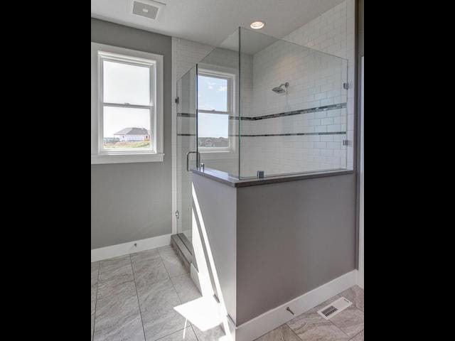full bathroom featuring visible vents, baseboards, and a shower stall